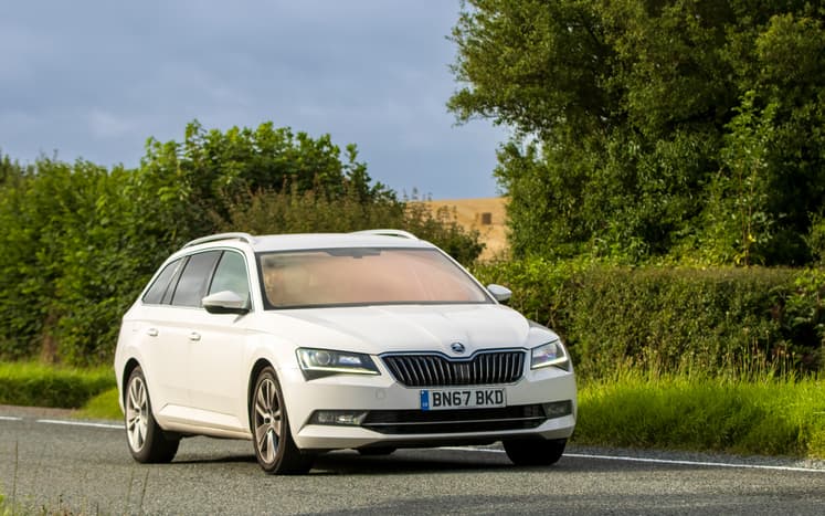 silver Scoda Superb driving on a sunny day